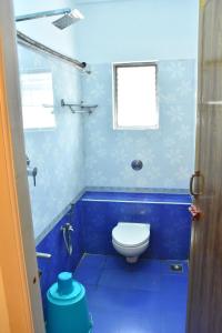 ein blaues Bad mit einem WC und einem Fenster in der Unterkunft Hotel Golden Bliss in Puducherry