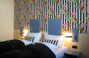 a bedroom with two beds and a wallpaper with pink flamingos at Hit the Sky in Sankt Christoph am Arlberg