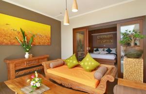 - une chambre avec un lit et des oreillers jaunes dans l'établissement Villa Wananta, à Ubud