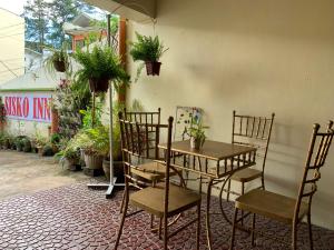 une table et des chaises dans une pièce ornée de plantes dans l'établissement Sisko Inn, à Baguio