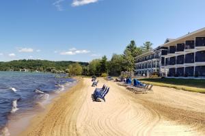 uma praia com cadeiras azuis e um edifício em Pointes North Beachfront Resort Hotel em Traverse City