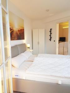 オストゼーバート・ゼリンにあるUrlaub und Erholung mit Charme und Stil auf Rügenのベッドルーム1室(壁に絵画が描かれた白い大型ベッド1台付)