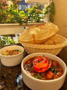 a table with a bowl of food and a basket of bread at The Art Hotel by VIA VARANASI in Varanasi