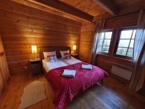 a bedroom with a bed in a wooden cabin at Dom Markówka Zakopane in Kościelisko