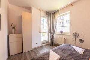 sypialnia z łóżkiem i oknem w obiekcie Victus Apartamenty, Apartament Bella w mieście Sopot