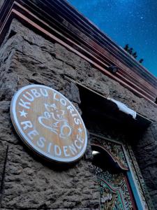 a sign on the side of a stone building at Kubu Loris Residence in Ubud