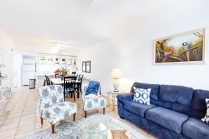 a living room with a blue couch and chairs at Tropical Breeze in South Padre Island