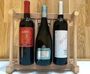 tre bottiglie di vino sedute su un ripiano in legno di Moji Sousedi - Apartmán Červená a Deštné v Orlických horách
