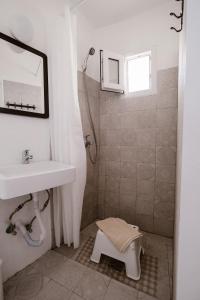 y baño con lavabo y ducha. en Boreas Stone House, en Anafi