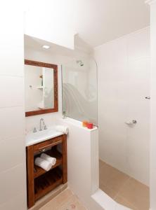 a white bathroom with a sink and a shower at Edificio Paseo del Sol in Necochea