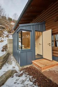 ein kleines Haus mit einer blauen Tür und einem Kühlschrank in der Unterkunft FIVE SEASONS - Hideaway Saalbach in Saalbach-Hinterglemm