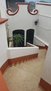 eine Treppe mit zwei schwarzen Stühlen und einer Pflanze in der Unterkunft Casa Vista Taxco in Taxco de Alarcón