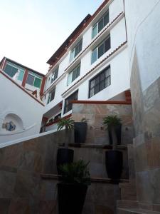 un edificio blanco con macetas en las escaleras en Casa Vista Taxco en Taxco de Alarcón