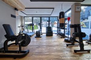 - une salle de sport avec des appareils de cardio-training et une grande fenêtre dans l'établissement Bonfanti Design Hotel, à Chienes