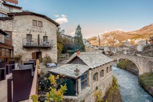 een gebouw met een brug over een rivier bij Hotel-Restaurant Kriva Ćuprija in Mostar