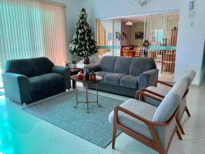 a living room with a couch and a christmas tree at Aruanã Palace Hotel in Colíder