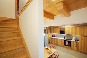 eine Küche mit Holzböden und eine Treppe in der Unterkunft Casa Corte dei Rode in Chies dʼAlpago