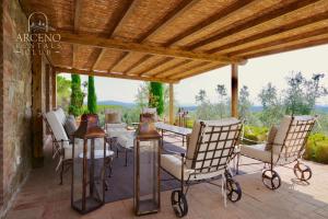 eine Terrasse mit einem Tisch und Stühlen sowie einer Holzdecke in der Unterkunft Camparone - Arceno Rentals Club in Castelnuovo Berardenga