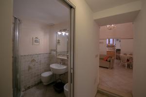 a bathroom with a sink and a toilet and a mirror at NICE APARTMENT in Porto Santo Stefano
