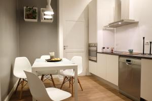 uma cozinha com uma mesa branca e cadeiras brancas em Casa Perrone, Ospedale Maggiore em Bolonha