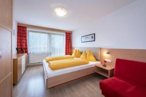 1 dormitorio con 1 cama y 1 sofá rojo en Residence Tauber, en Valles