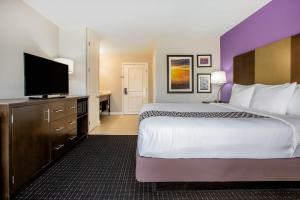 a hotel room with a large bed and a flat screen tv at La Quinta by Wyndham Pomona in Pomona