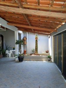 a patio with a wooden ceiling and a tree on the wall at Hospedagem domiciliar in Guarujá