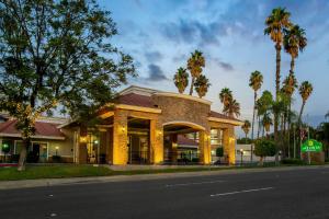 a building on the side of a street with palm trees at La Quinta by Wyndham Pomona in Pomona