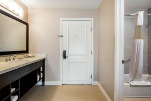 a bathroom with a white door and a sink at La Quinta by Wyndham Pomona in Pomona