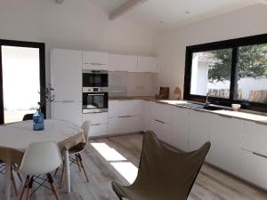eine Küche mit einem Tisch und Stühlen im Zimmer in der Unterkunft Villa de Gascogne in Lanton