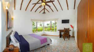 a bedroom with a bed with a ceiling fan and a desk at Hotel Finca Del Café in Santa Rosa de Cabal