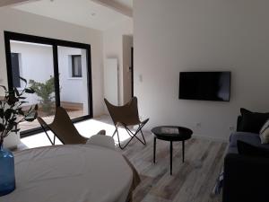 een kamer met een bed en stoelen en een televisie bij Villa de Gascogne in Lanton