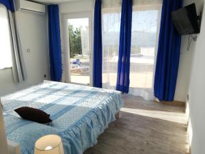 Vila Maslinica في بوتشيتشا: غرفة نوم بسرير ونافذة كبيرة