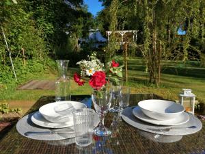 a table with plates and glasses and flowers on it at Villa Amalia in Eutin