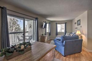 uma sala de estar com um sofá azul e uma mesa em Ski-In Ski-Out Wintergreen Condo with Balcony em Mount Torry Furnace
