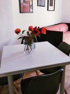 een witte tafel met bloemen in een vaas erop bij Appartamento Holiday cir 0050 in Saint Vincent
