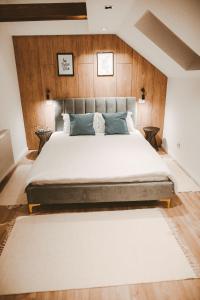 a bedroom with a large bed with wooden walls at Vila Casa din gradina in Voivodeni