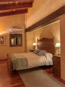 1 dormitorio con 1 cama grande y espejo en Serrat del Vent - Adults only, en Ribes de Freser