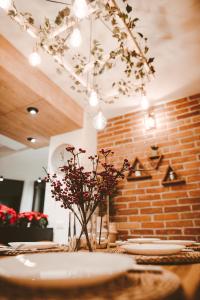 a table with plates and a vase with flowers on it at Vila Casa din gradina in Voivodeni