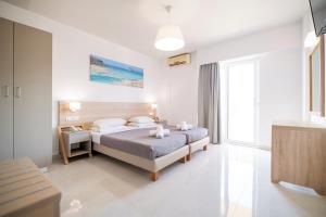 a bedroom with a bed and a large window at Horizon Beach in Stalida