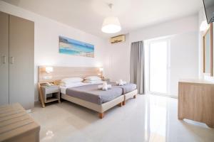 a bedroom with a bed and a large window at Horizon Beach in Stalís