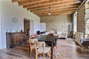 Un comedor con una mesa y sillas y una pared de ladrillos. en Maison de famille Penmarch, en Penmarch