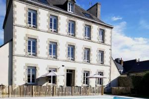 Un gran edificio blanco con sombrillas delante. en Maison de famille Penmarch, en Penmarch