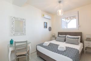 a bedroom with a bed and a desk and a mirror at Nathalie's Beachfront Apartment in Rethymno Town