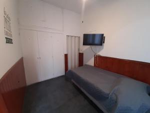 a small bedroom with a bed and a tv on the wall at Departamento centro salta in Salta