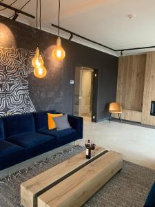 a living room with a blue couch and a coffee table at Plein la vue in Barvaux