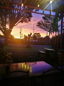 puesta de sol sobre un patio con mesa y árboles en Hotel Vale's, en Chiles
