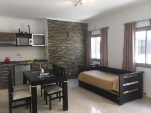 a bedroom with a bed and a table and a kitchen at Gran Tuyu in San Clemente del Tuyú