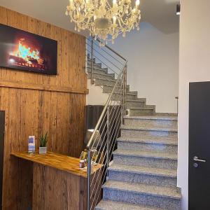 a staircase with a chandelier in a room at Hotel Waitzingers in Landsberg am Lech