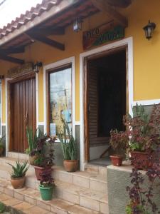 a building with potted plants sitting outside of it at Pousada Pico Da Vila in Vale do Capao